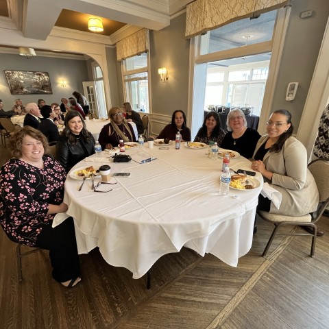 A table of attendees smile for the camera.